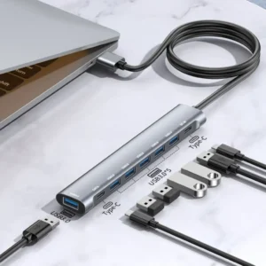 A silver, aluminum 8-in-1 USB hub featuring 6 USB 3.0 ports, a Type-C data port, and a Type-C power input, with a long 1.2m cable.